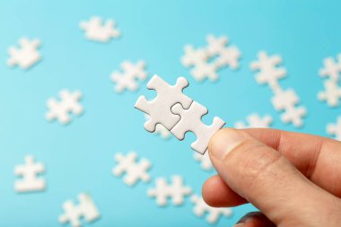  Bulmaca parçaları birbirine bağlı. Mavi arka planda beyaz yapboz parçaları var. İş, ortak, çözüm, ittifak, sendika kavramı.