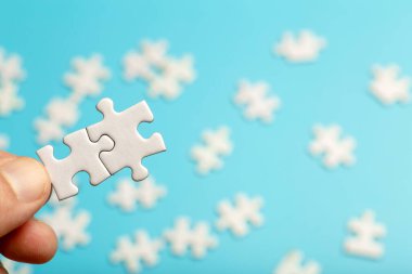  Bulmaca parçaları birbirine bağlı. Mavi arka planda beyaz yapboz parçaları var. İş, ortak, çözüm, ittifak, sendika kavramı.