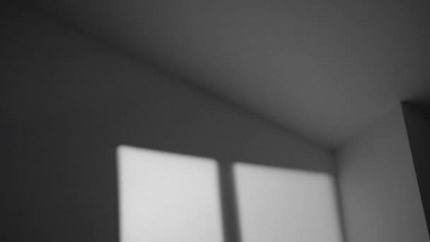 Stín okna se v noci pohybuje po povrchu šedé stěny v místnosti doma. Rozmazané stíny pozadí s efektem překrytí, šumem a strukturou zrna. — Stock video
