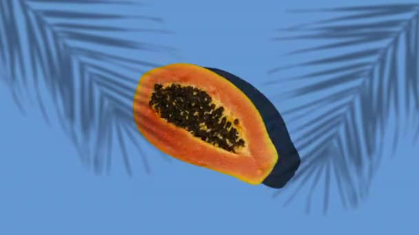 La papaya de frutas tropicales gira sobre un fondo soleado de color con sombras de una palmera. Detener efecto de movimiento. Verano, vitaminas, comida, jugo, concepto mínimo — Vídeo de stock
