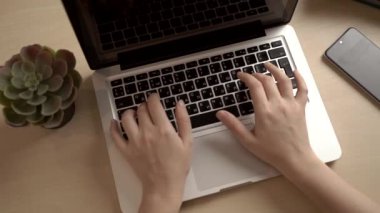 Kadın ofiste ya da internette bir bilgisayar için çalışıyor. Eller masaüstünde dizüstü bilgisayarın arkasında. Yazma, yazma, internet, teknoloji konsepti.