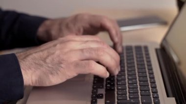 Adam ofiste ya da internette bir bilgisayar için çalışıyor. Eller masaüstünde dizüstü bilgisayarın arkasında. Yazma, yazma, internet, teknoloji konsepti.