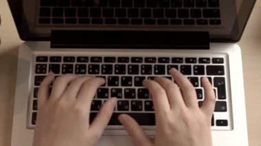 Kadın ofiste ya da internette bir bilgisayar için çalışıyor. Eller masaüstünde dizüstü bilgisayarın arkasında. Yazma, yazma, internet, teknoloji konsepti.