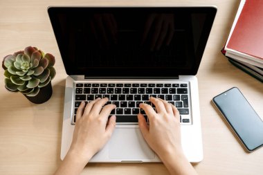 Dizüstü bilgisayar ve eller iş arka planında. Ofiste ya da evde bir masaüstü masasında bilgisayar klavyesinde yazı yazmak. Bilgisayar web teknolojisi, satışlar, internet, pazarlama kavramı.