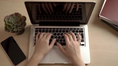 Kadın ofiste ya da internette bir bilgisayar için çalışıyor. Eller masaüstünde dizüstü bilgisayarın arkasında. Yazma, yazma, internet, teknoloji konsepti.