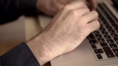 Adam ofiste ya da internette bir bilgisayar için çalışıyor. Eller masaüstünde dizüstü bilgisayarın arkasında. Yazma, yazma, internet, teknoloji konsepti.