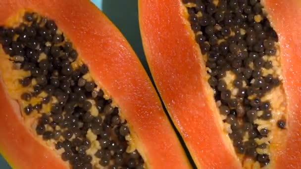 Tropisch fruit papaya op een gekleurde zonnige achtergrond met schaduwen van een palmboom. Zomer, vitaminen, voedsel, sap, minimaal concept — Stockvideo