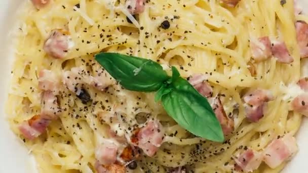Pasta en la placa gira. Pasta de comida italiana con queso, especias y salsa en la mesa de la cocina — Vídeos de Stock