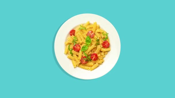 Massa na placa gira sobre fundo azul isolado vazio. Macarrão italiano com queijo, tomate, especiarias e molho na mesa da cozinha — Vídeo de Stock