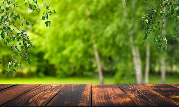 Лісовий дерев'яний стіл фону. Літній сонячний луг з зеленою травою, фон лісових дерев і сільська дерев'яна поверхня для товарів, продуктів, продуктів харчування — стокове фото