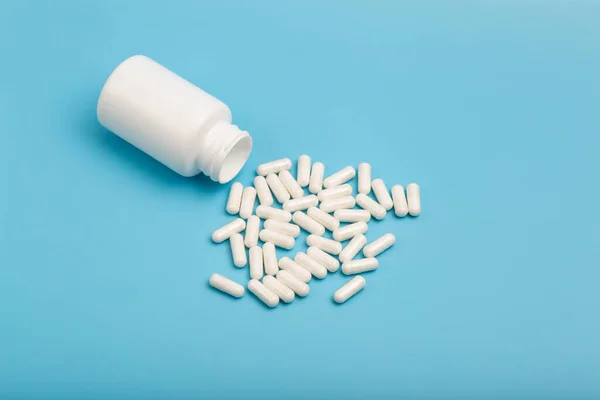 Farmaceutisk marknad apotek koncept. Piller och vitaminer med en burk på en tom minimal bakgrund. Läkemedel, antibiotika, kosttillskott, multivitaminer. — Stockfoto