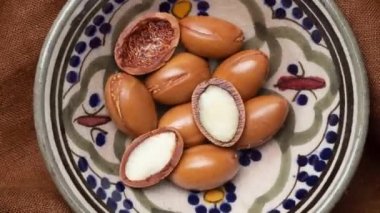 Doğal bir kırsal arka planda Argan tohumları. Bitkili Argan yağı fındığı. Kozmetik ürünleri ve doğal yağlar.