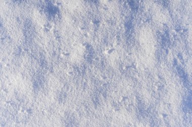 Karlı bir arka plan ve kışın güneşli bir günde kar yüzeyi..