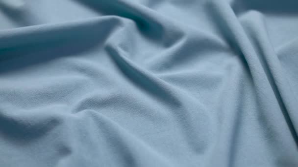 Tecido pano de fundo. Textura algodão material têxtil closeup. Tecido plissado ondulado azul em uma mesa de alfaiates — Vídeo de Stock