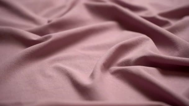 Fondo de tela de tela. Textura de algodón textil material de primer plano. Tela plisada ondulada rosa en una mesa de sastres — Vídeos de Stock