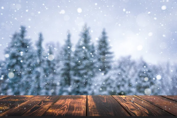 Zimní les s dřevěným stolem pozadí. Rozmazaná sněhová krajina a prázdný venkovský stůl pro produkt nebo zboží. — Stock fotografie