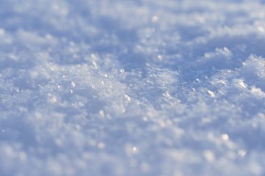 Karlı bir arka plan ve kışın güneşli bir günde kar yüzeyi..