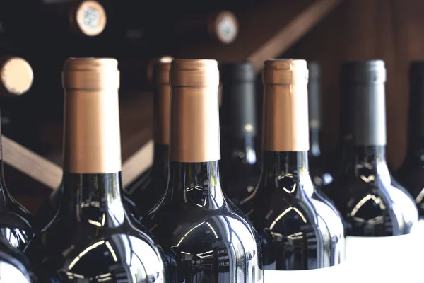 Botellas de vino con etiquetas en blanco en el mostrador de una licorería. Fondo del vino. Enfoque seleccionado —  Fotos de Stock