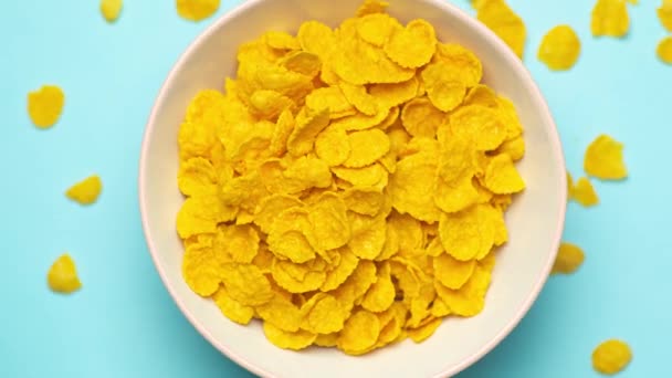 Breakfast corn flakes rotate in a bowl on the kitchen table. Cereals close up background. Healthy food and breakfast for kids. — ストック動画