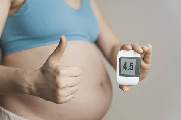 Gestational diabetes in pregnancy. Pregnant woman check sugar level with a glucometer. Glucose intolerance, diabetic fetopathy, hypoglycemia, insulin resistance concept