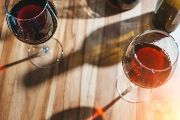 Weinprobe. Ein Glas Rotwein auf dem Hintergrund eines Restauranttisches mit Flasche bei einem Abendessen oder einer Eventparty. — Stockfoto