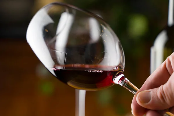 ワインの試飲。夜のディナーやイベントパーティーでボトル付きのレストランテーブルの背景にある赤ワインのガラス. — ストック写真