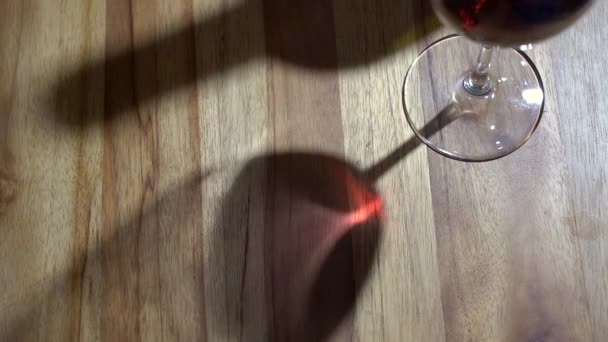 Un verre de vin rouge. Dégustation de vin versant un verre sur le fond d'une table en bois d'un restaurant ou d'un bar. Goût, arôme, richesse. Boissons alcoolisées issues du concept de vendange. — Video