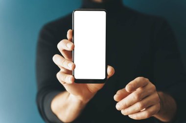 Akıllı telefon boş ekran sunumu. Genç bir adam elinde beyaz ekran maketi olan bir telefon tutuyor. İnternet, uygulamalar, iş dünyası, teknoloji kavramı.