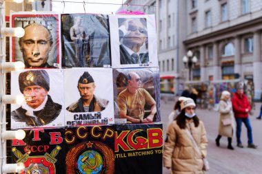 Moskova, Rusya - 28 Şubat 2022: Rusya Devlet Başkanı Putin 'in KGB' nin sembollerinin yanında askeri üniformalı bir portresi. Moskova 'da Turist Arbat Caddesi.