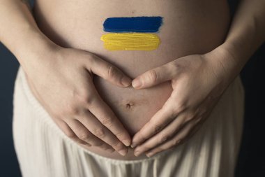 The War in Ukraine, Ukrainian conflict background. The Ukrainian flag is painting on the belly of a pregnant woman. Peace, pacifism, activism, no war and support concept clipart