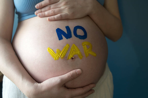 The War in Ukraine, Ukrainian conflict background. The Ukrainian flag is painting on the belly of a pregnant woman. Peace, pacifism, activism, no war and support concept