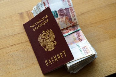 Rus rublesi banknotlar ve pasaport. Tercümesi: Rusya Federasyonu pasaportu. Enflasyon, yaptırımlar ve Rus ekonomisinin çöküşü. Düşen nakit tasarrufu ve bütçe