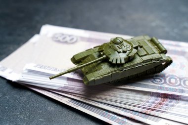 Rusya 'da ekonomik kriz. Rus rublesi üzerinde oyuncak askeri tank. Ukrayna 'da savaş çatışması, Rusya' da ekonomik yaptırımlar ve enflasyon