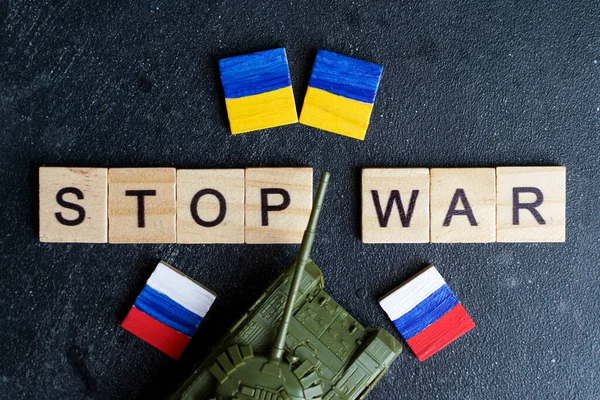Російська війна в українській концепції конфлікту. Напис "Зупиніть війну" і "іграшковий бак" на темному тлі. Мир, пацифізм, активізм і підтримка ідеї — стокове фото