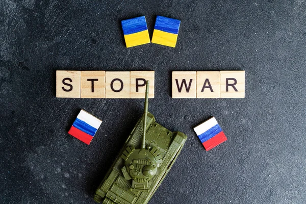 Російська війна в українській концепції конфлікту. Напис "Зупиніть війну" і "іграшковий бак" на темному тлі. Мир, пацифізм, активізм і підтримка ідеї — стокове фото