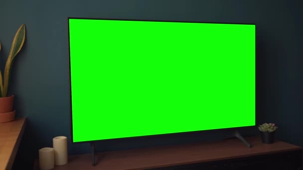 TV screen mockup background. Lcd tv monitor with blank green screen in living room while watching — Video Stock