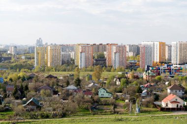 Rusya 'da, Moskova bölgesinde yeni apartmanlar inşa etmek. Evlerin özel sektörü bir yerleşim yerinin arka planına karşı. Pazar, konut, iş konsepti