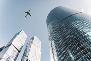 Uçuş uçağı geçmişi olan iş merkezi binaları. Finans bölgesinde modern ofis mimarisi. Güneşli havada cam gökdelenler. Ekonomi, para, kalkınma, pazar kavramı.