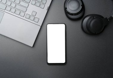 Siyah arka planda boş ekranlı akıllı telefonlu kulaklıklar. Müzik uygulaması, ses dinleme, podcast konsepti. Yüksek kalite fotoğraf