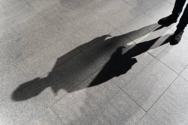 Sokakta yerde yatan yalnız bir insanın karanlık gölgesi. Sigaralı bir yabancı. Endişe, depresyon, yalnızlık, korku konsepti. Yüksek kalite fotoğraf