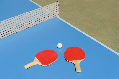 Masa tenisi masası arka planı. Tenis raketleri ve mavi bir spor masasında bir top. Yüksek kalite fotoğraf