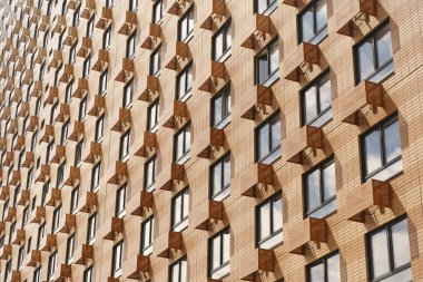 Pencereleri pencereli, çok katlı, yüksek katlı bir apartmanın ön cephesi. Yeni bir şehir bölgesinin tipik mimari ve tasarımı. İnşaat, müteahhit, konut