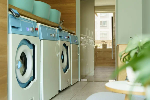 Laundry room interior. Washing machines and dryers in a bright home sunny laundry room. High quality photo
