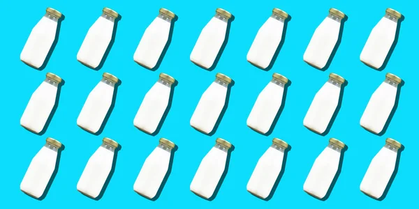 Milk bottle minimal background. Many glass bottles of white cows milk or yogurt in a pattern. High quality photo