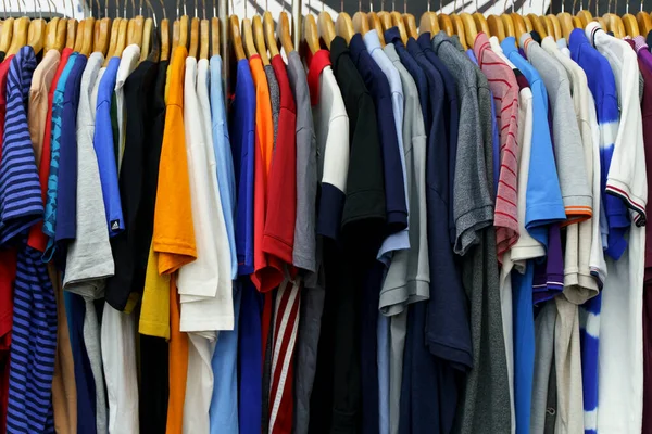 Second hand vintage clothes in a store on sale. Fashionable European used retro jeans, t-shirts, dresses, pants and accessories. Recycling and life extension for clothes concept. High quality photo