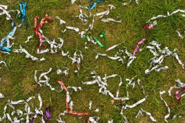 Plastic pollution after a party, event, celebration. Plastic confetti on the grass. Environmental pollution, recycling, waste concept. High quality photo