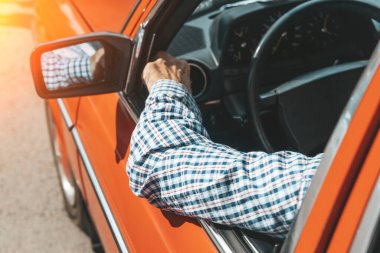 Driver travels in the summer in a vintage car. Lifestyle, vintage, vacation, road trip concept. High quality photo