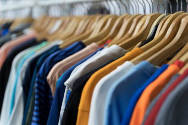 Second hand vintage clothes in a store on sale. Fashionable European used retro jeans, t-shirts, dresses, pants and accessories. Recycling and life extension for clothes concept. High quality photo