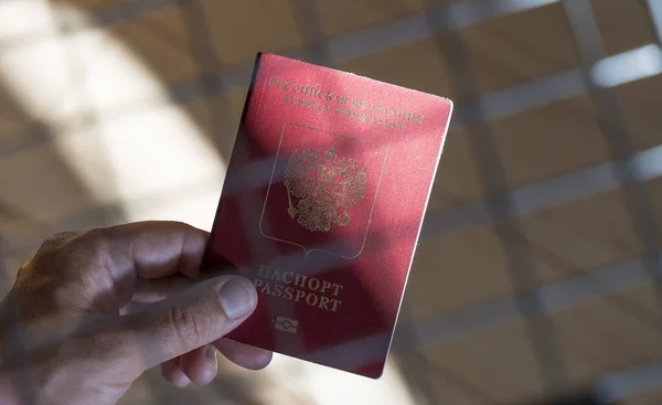 Russian passport in the hands of a man. Prohibition of Schengen visas for Russian tourists to travel to the European Union concept. High quality photo