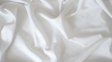 White fabric. Drapery wavy texture white linen cloth background on morning sunshine. Clean clothes concept. High quality FullHD footage